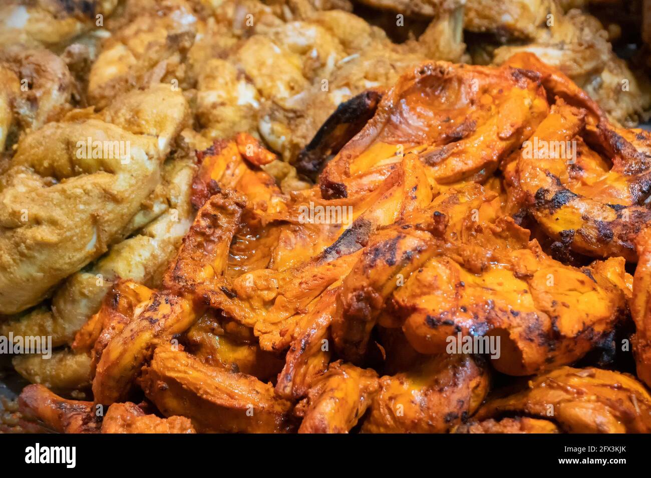 Spicy roasted tandoori butter chicken , prepared for sale at evening as street food in Old Delhi