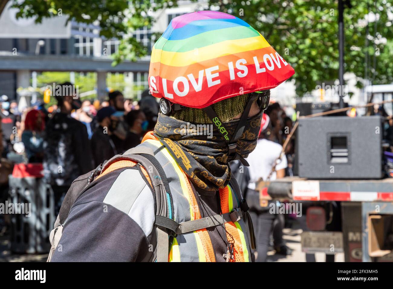 Black Lives Matters Protest in Yonge-Dundas Square in Toronto, Canada. A person wears a helmet with a rainbow flag and reading 'Love is Love' Stock Photo