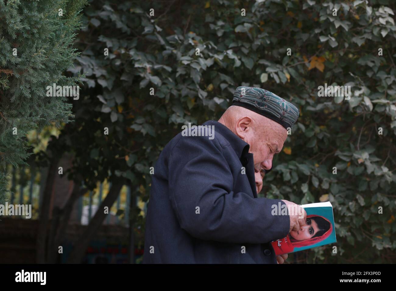 Uighur old man reading outside the Id Kah Mosque .Kashgar, Xingiang, China 2019 Stock Photo