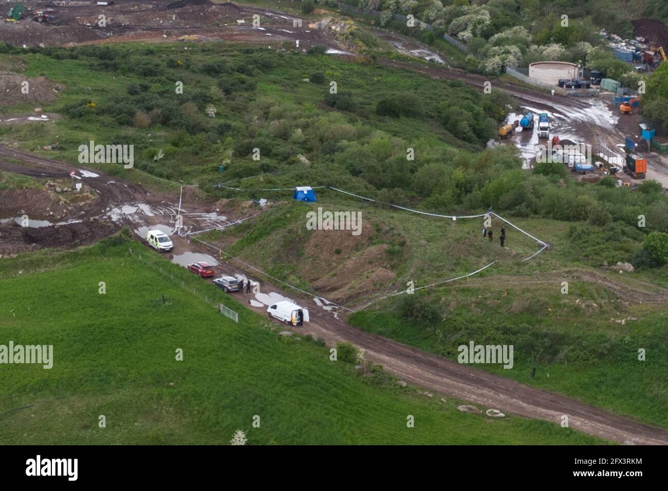 Kingswinford, UK. 25th May, 2021. Aerial views of Himley Quarry Landfill where a poice scene has been set up after a human bone was found. A blue tent is visible along with police vehicles and officers. West Midlands Police are searching the site, on top of a landfill mound after the grim discovery. Pic by Credit: Katie Stewart/Alamy Live News Stock Photo