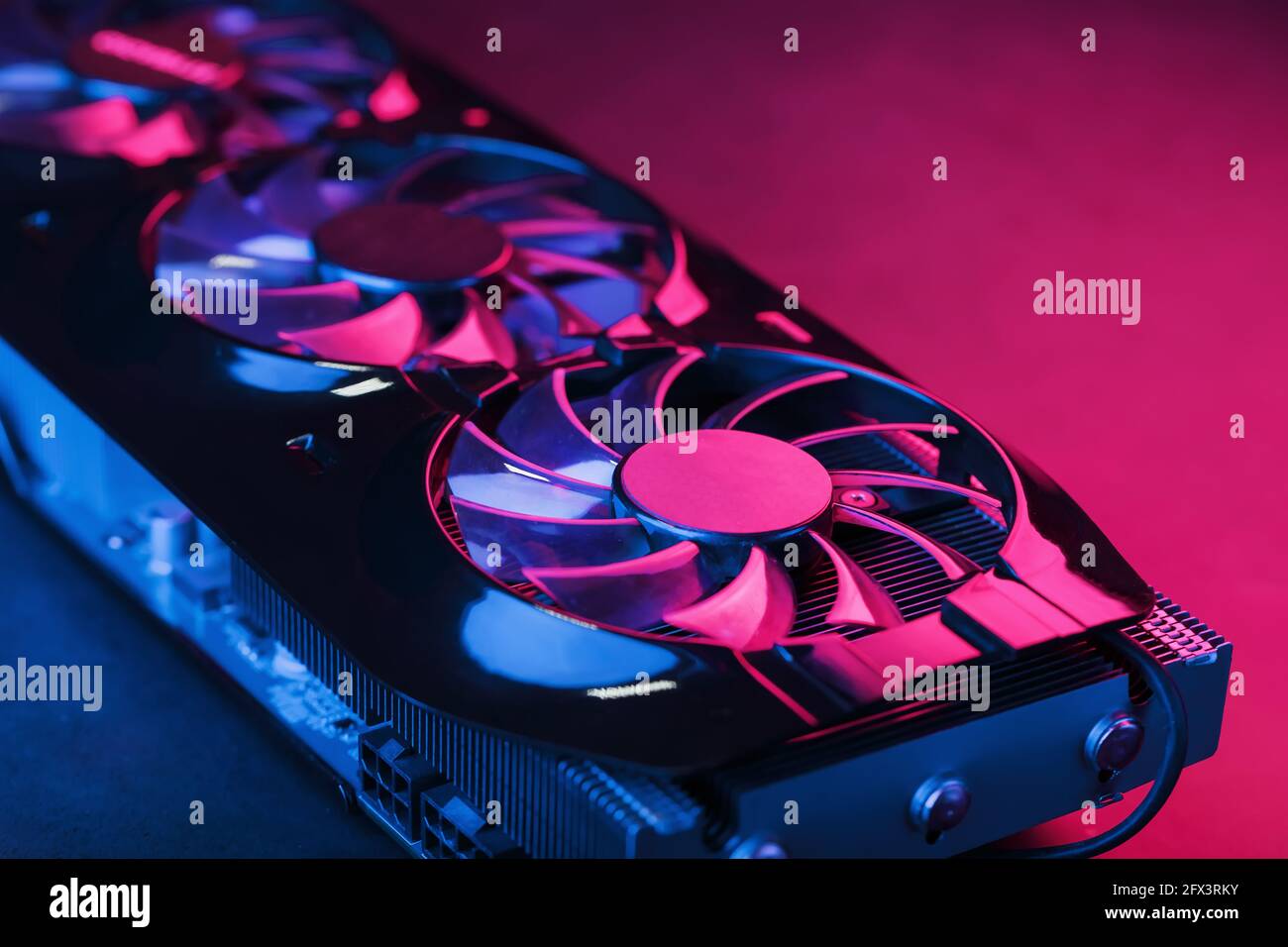 Large and powerful graphics card with three fans with blue pink light. The  concept of a cyberpunk video chip for gaming and cryptocurrency mining. Dar  Stock Photo - Alamy