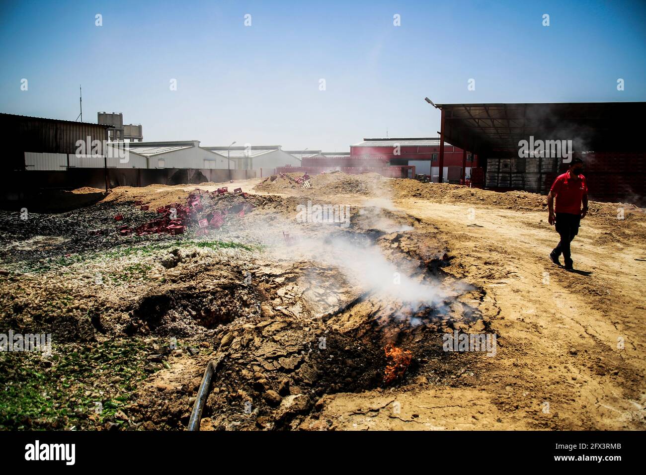 A Palestinian worker salvages items from the damaged Coca Cola factory
