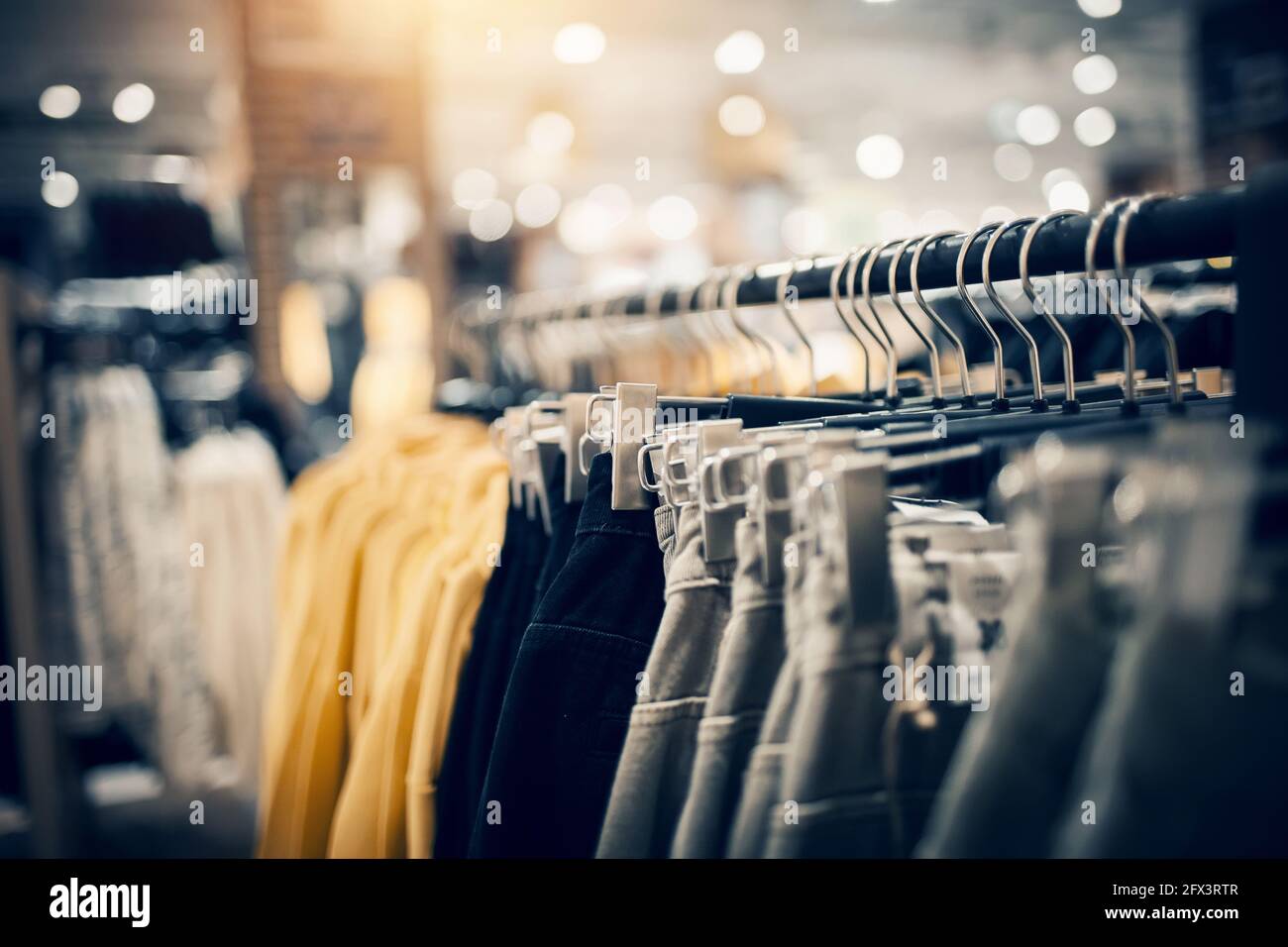 Shopping in store. Clothes on hangers in shop for sale. Blur background.  Fashionable clothes in a boutique. Various clothing on market Stock Photo -  Alamy