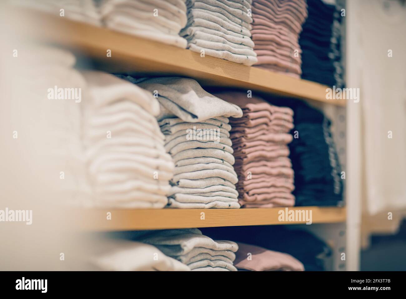 Stacks of clothes. Shopping in store. Clothing on the shelves in shop ...