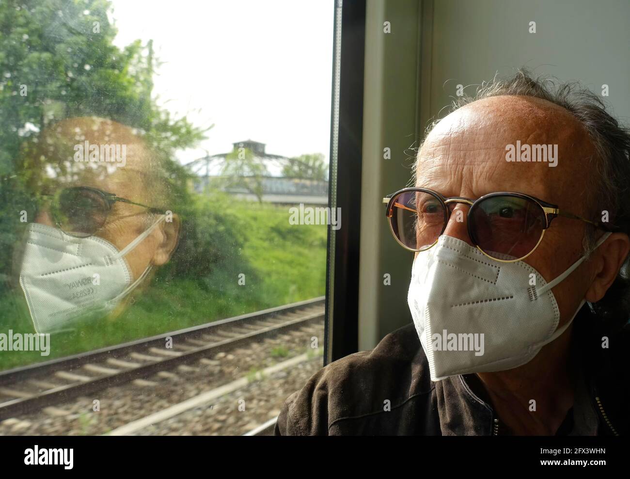 65-year-old man with facial mask on the train, Berlin Stock Photo