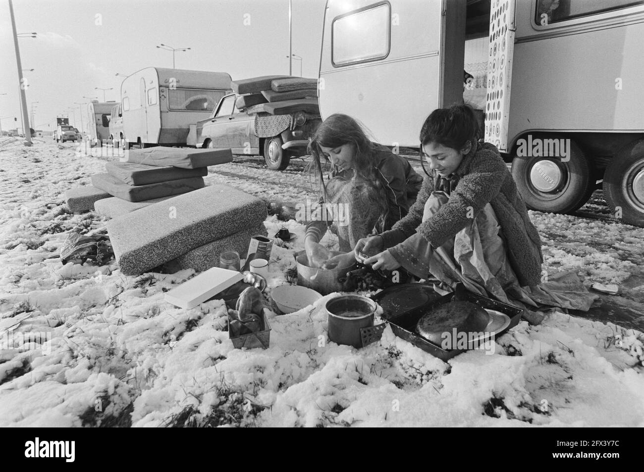 The group of gypsies trying to enter Germany on piece of no man's land between the Netherlands and Belgium . Two women washing dishes outside in the snow, 13 January 1981, women, gipsies, The Netherlands, 20th century press agency photo, news to remember, documentary, historic photography 1945-1990, visual stories, human history of the Twentieth Century, capturing moments in time Stock Photo