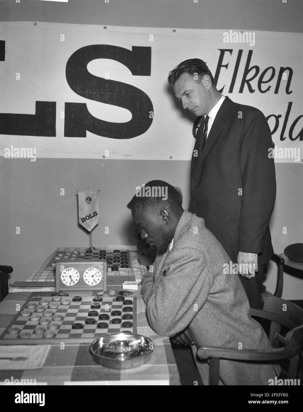 Third International Tournament of Draughts in Krasnapolski. Baby Sy from Senegal. Van Dijk looks on, January 1, 1962, checkers, sports, The Netherlands, 20th century press agency photo, news to remember, documentary, historic photography 1945-1990, visual stories, human history of the Twentieth Century, capturing moments in time Stock Photo