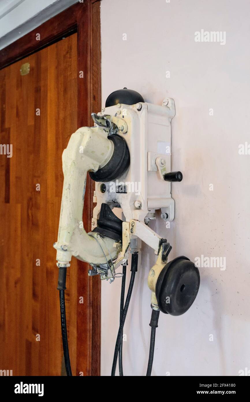 Old vintage telephone set on a ship, close-up against the wall Stock Photo
