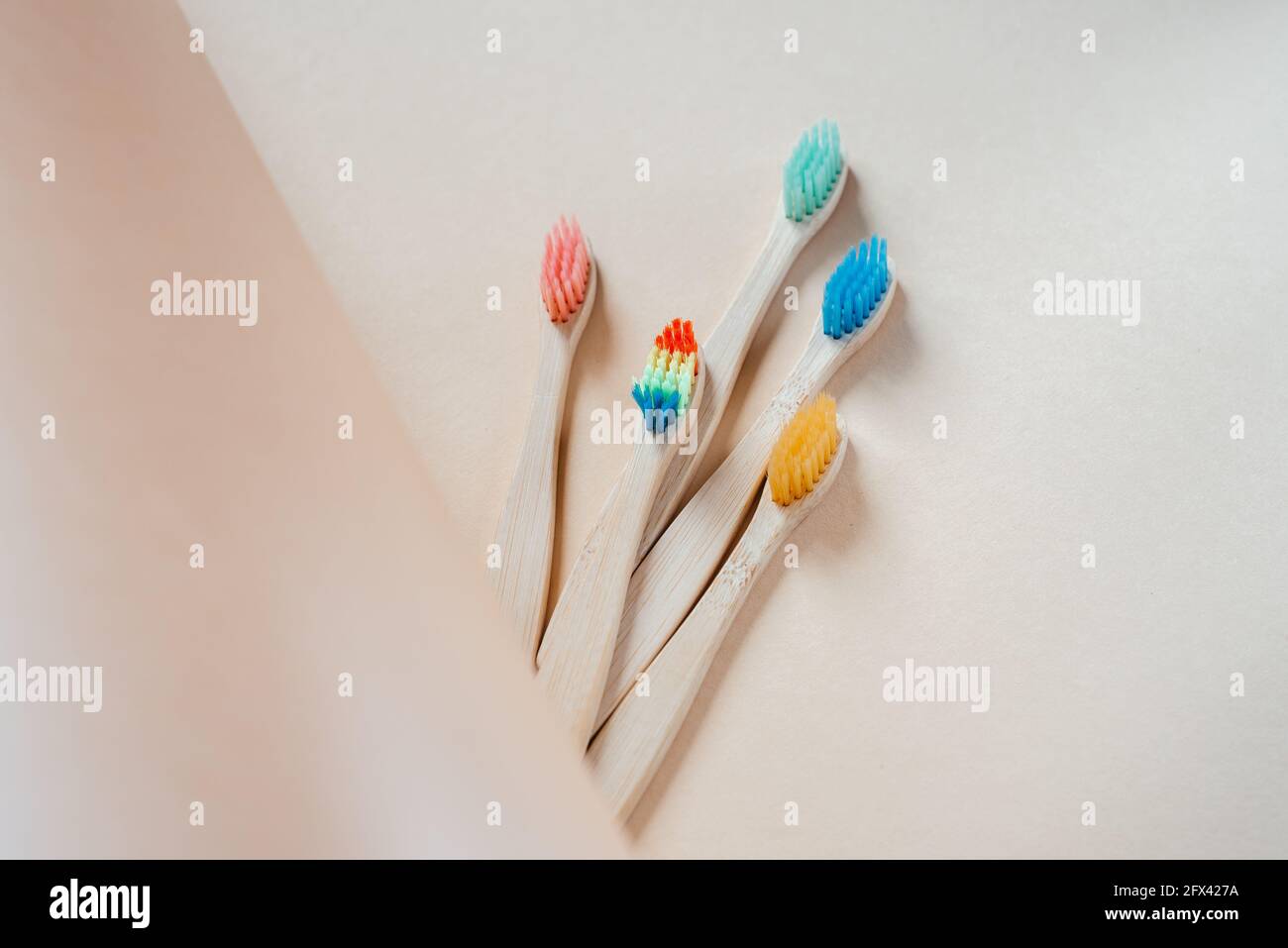 Colorful eco friendly bamboo toothbrushes on light pastel background ...