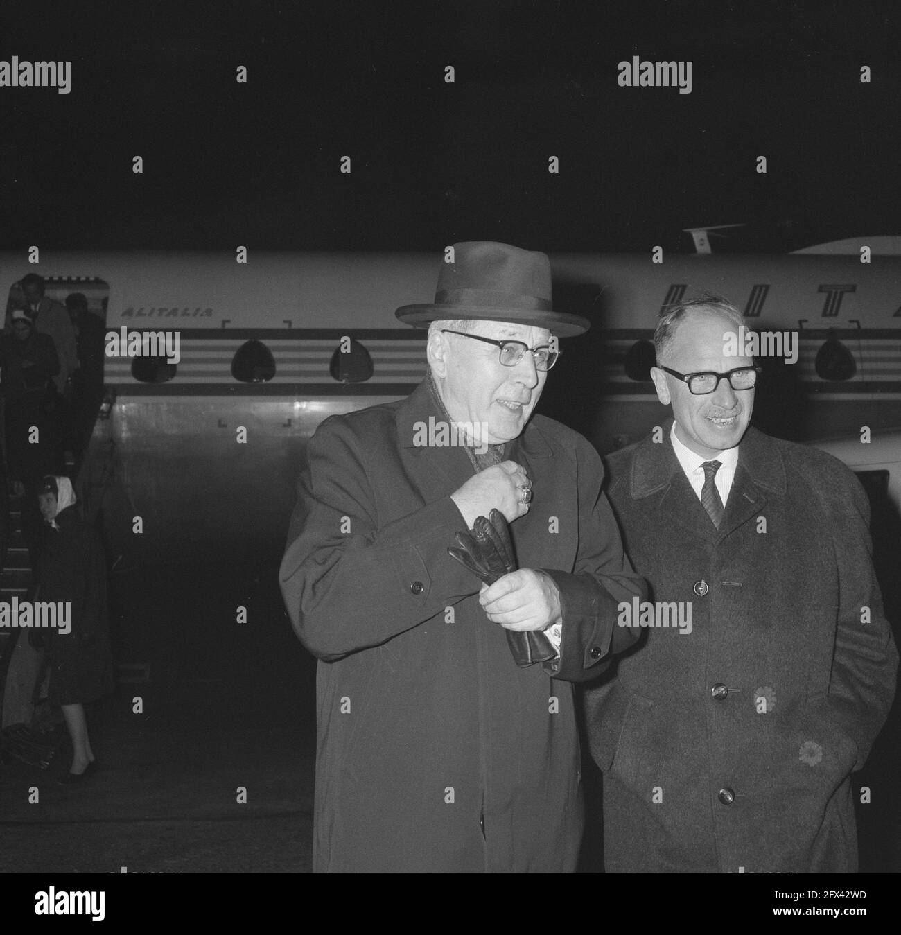 The Cardinal (r.) as he poses for the plane and holds his gloves ...