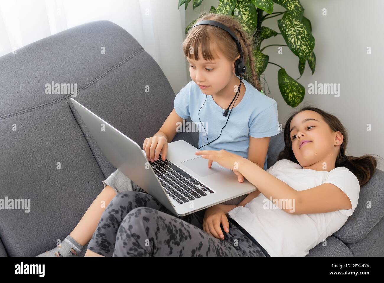 Distance learning online education. A school girls study at home and do ...