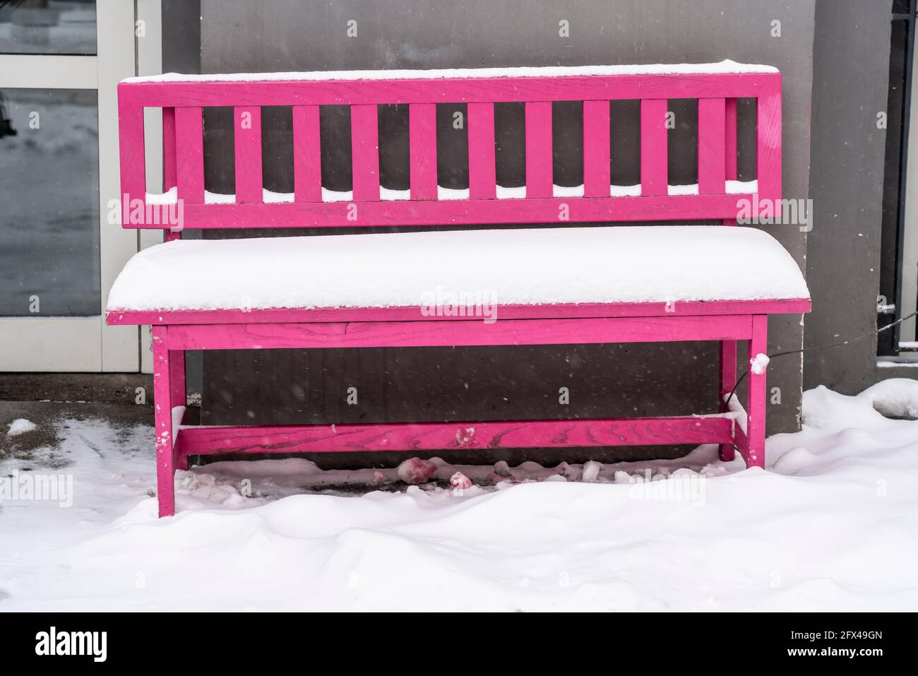 Pink Park bench, covered with snow, Inner city of Essen, onset of winter, lots of fresh snow and daytime temperatures below minus 5 degrees, Essen, NR Stock Photo