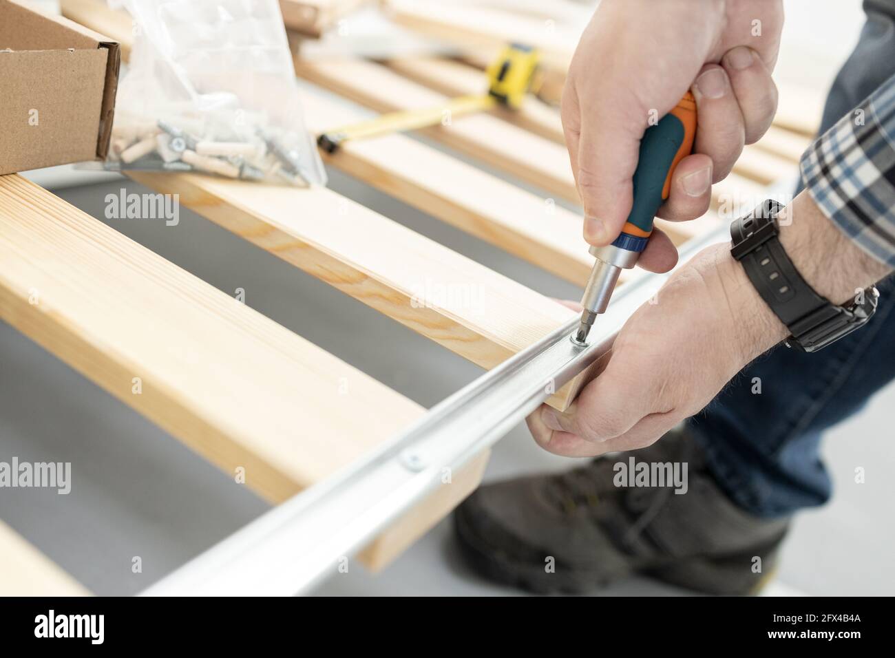 Close up of a hands Assembling a bed frame using a screwdriver. Furniture mounting concept Stock Photo