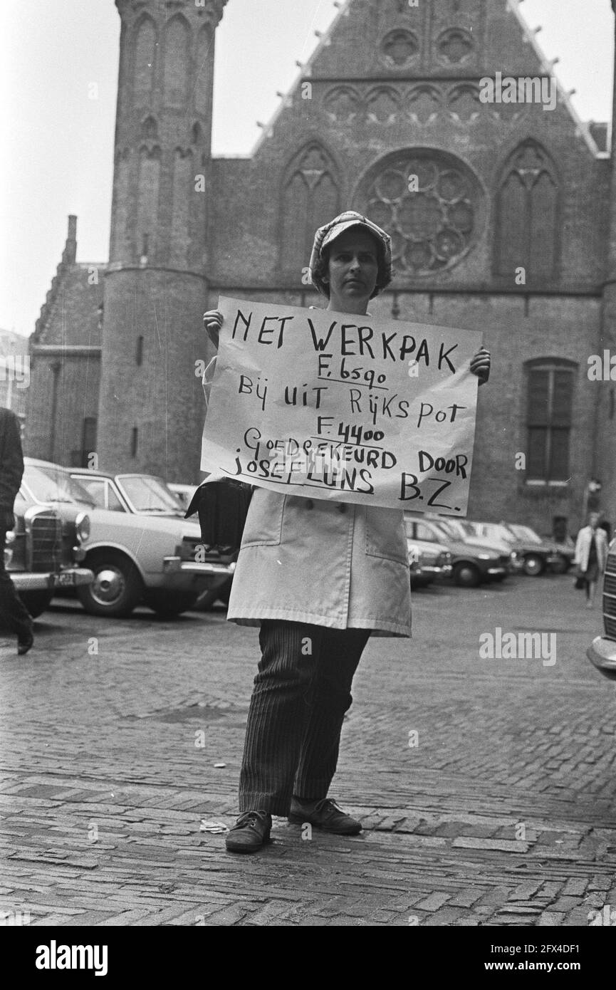 Demonstrator in Binnenhof holding a sign that reads, Net work suit F. 6590. At from Reichspot F. 4400. Approved by Josef Luns B.Z. Foreign Affairs], May 25, 1971, demonstrations, signs, placards, costumes, squares, The Netherlands, 20th century press agency photo, news to remember, documentary, historic photography 1945-1990, visual stories, human history of the Twentieth Century, capturing moments in time Stock Photo