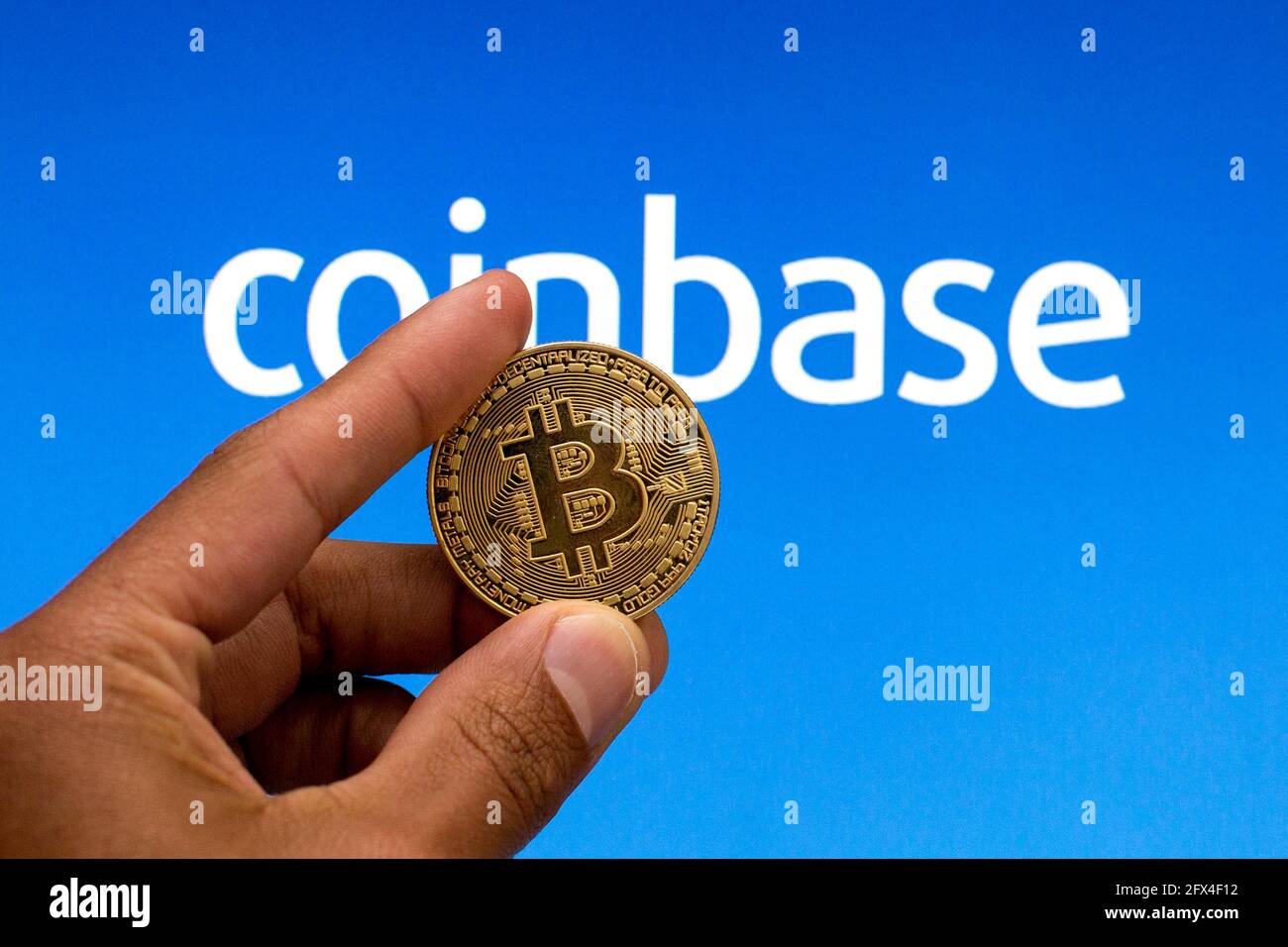 In this photo illustration, a Bitcoin is seen with Coinbase logo in the  background Stock Photo - Alamy