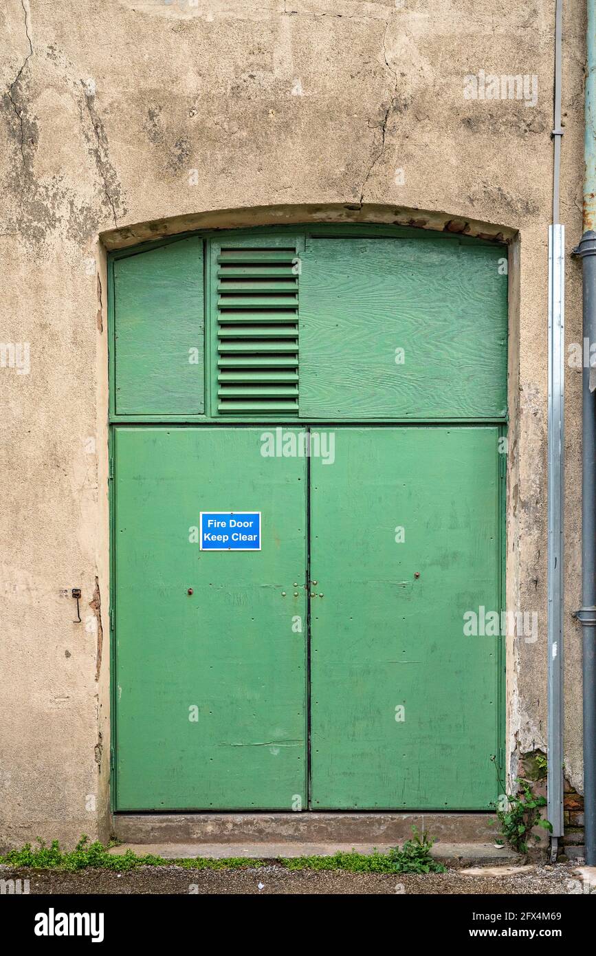 Green painted metal doors to warehouse building Stock Photo
