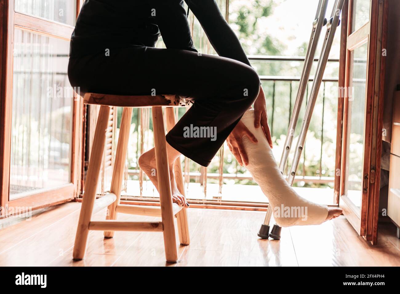 Close-up of a woman with a broken ankle, sitting on a chair Stock Photo