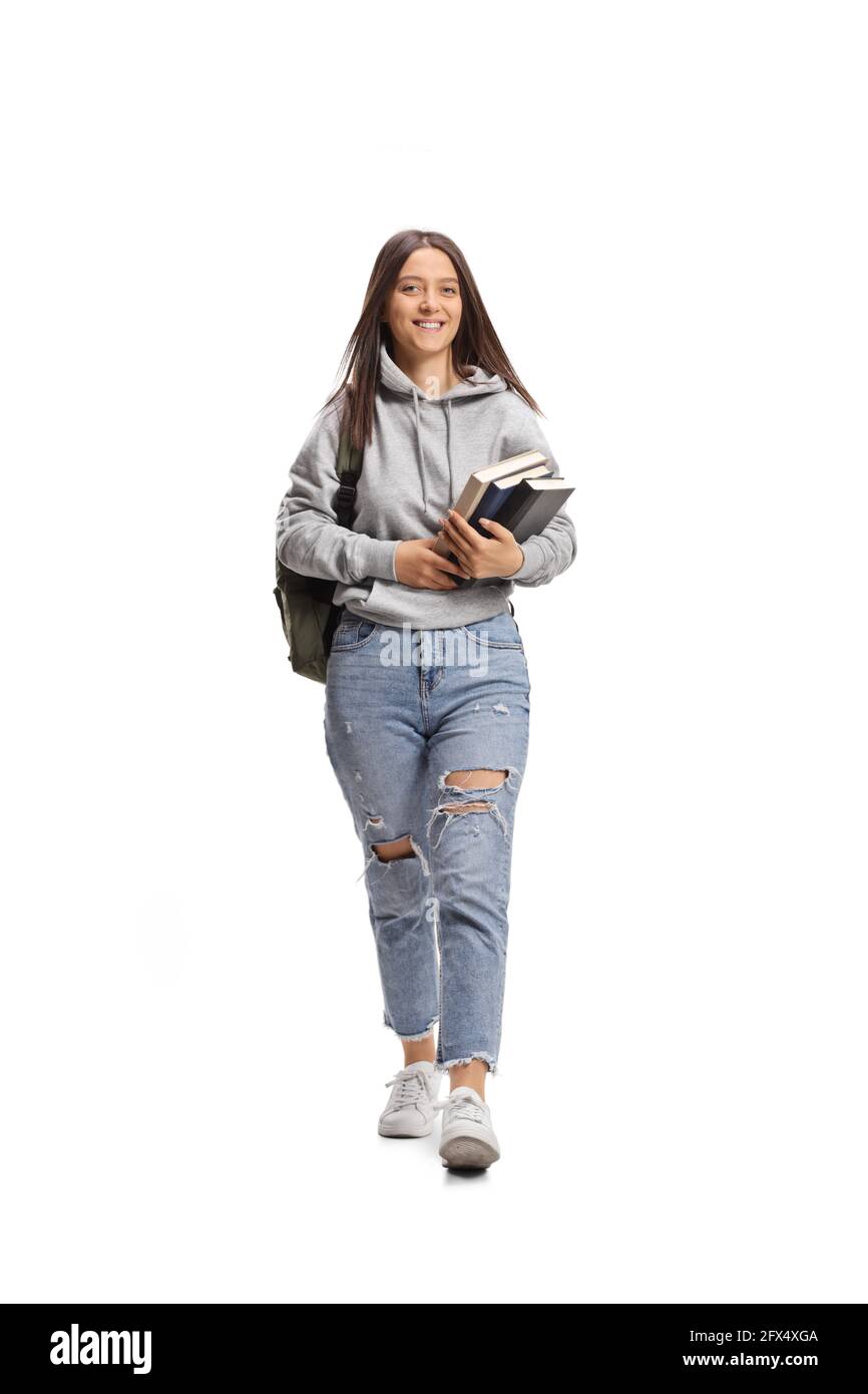 Full length portrait of a female student carrying books and walking ...