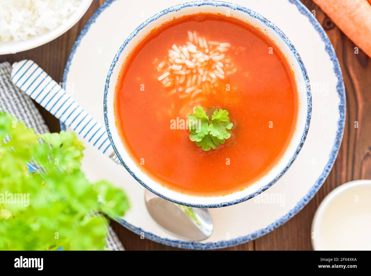Bright, clean close-up of a bowl of tomato soup with rice, happy, spring colors, top view Stock Photo
