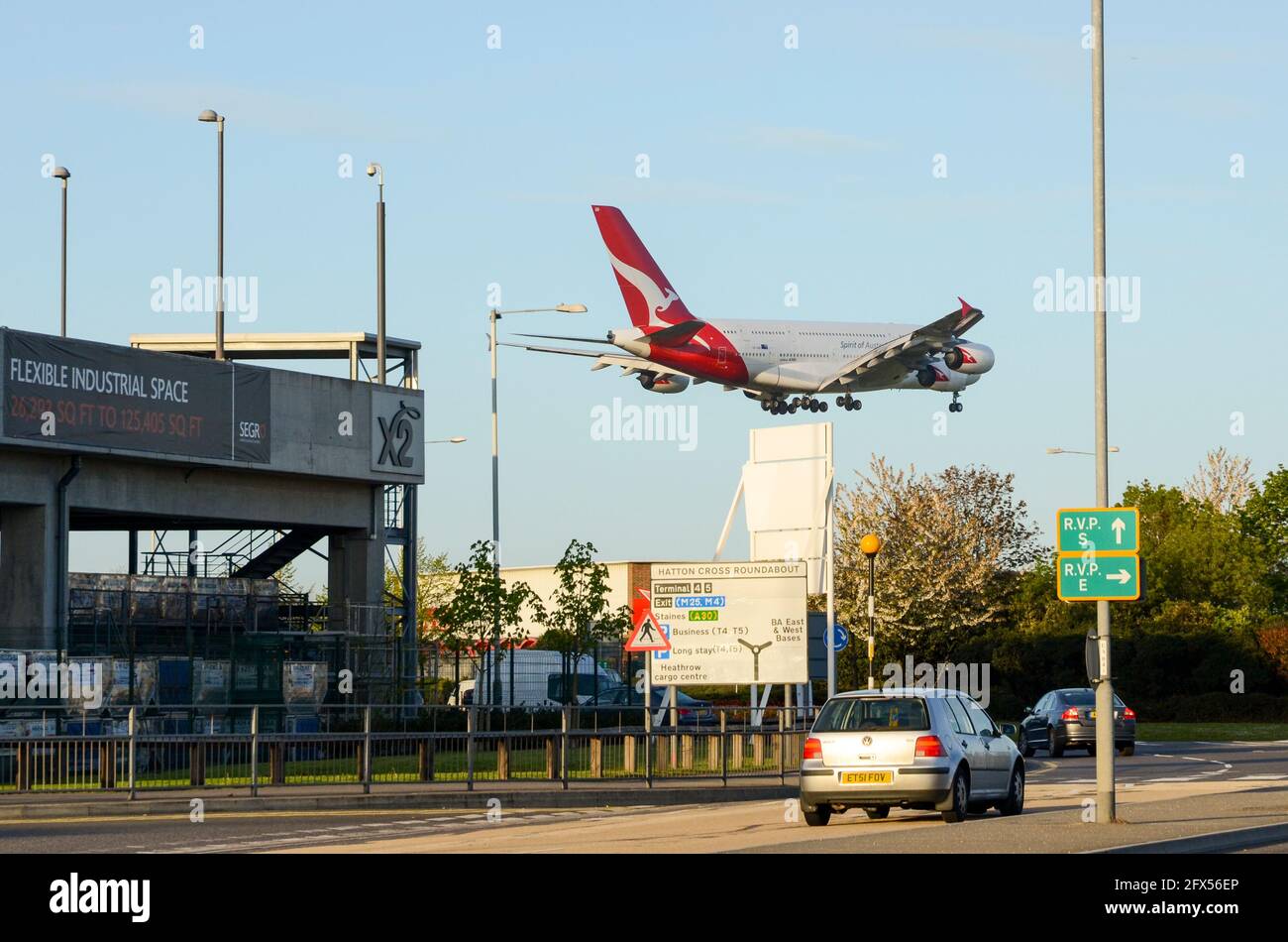 Qantas Airbus A380 airliner jet plane landing at London Heathrow Airport, UK, over Hatton Cross, Hounslow, UK. Cars on road underneath Stock Photo