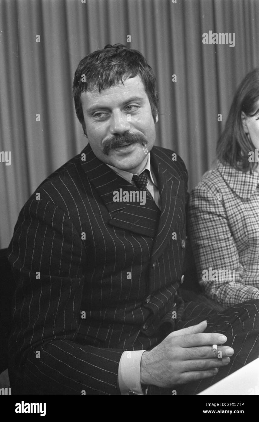 Oliver Reed hands clasped wearing costume as he appears in film