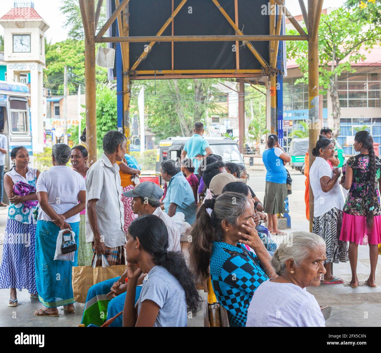 Sri Lankan passengers waiting for buses at the bus stand, Buttala, Southern Province, Sri Lanka Stock Photo