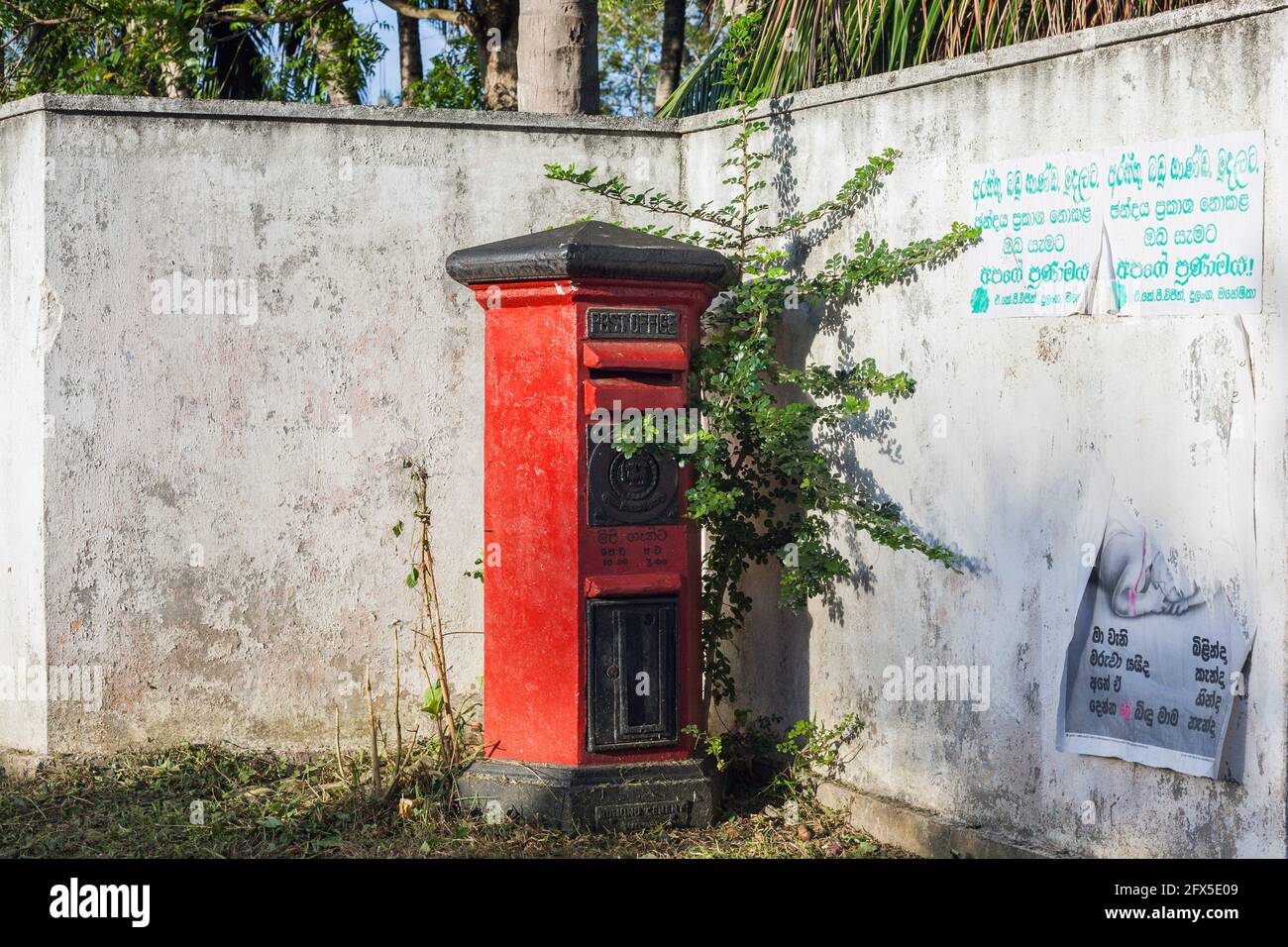 Traditional Royal Mail red collection letter post box on street, Southern Province, Tangalle Stock Photo