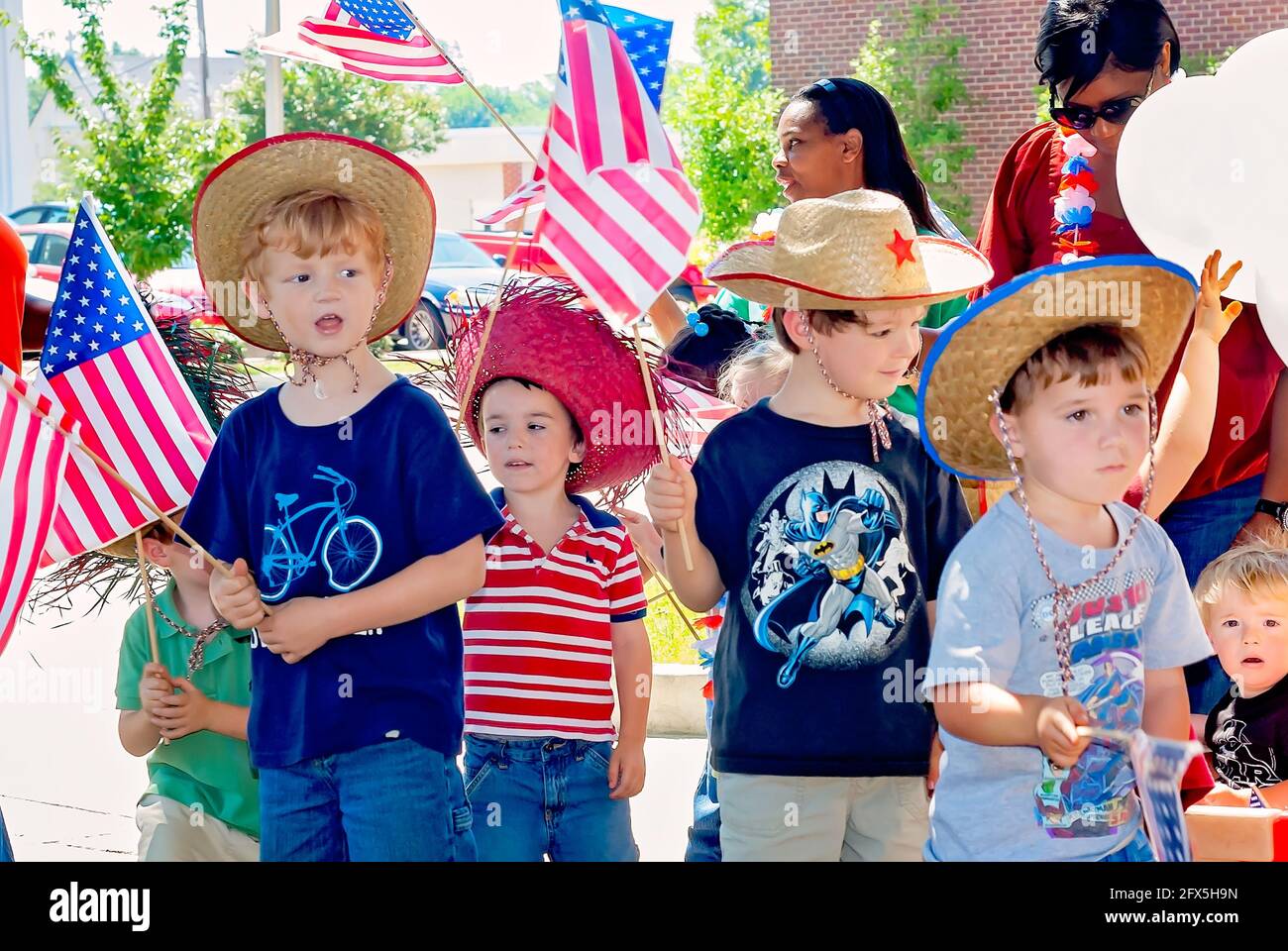 Children wave American flags during a Fourth of July parade, June 30, 2011, in Columbus, Mississippi. Stock Photo