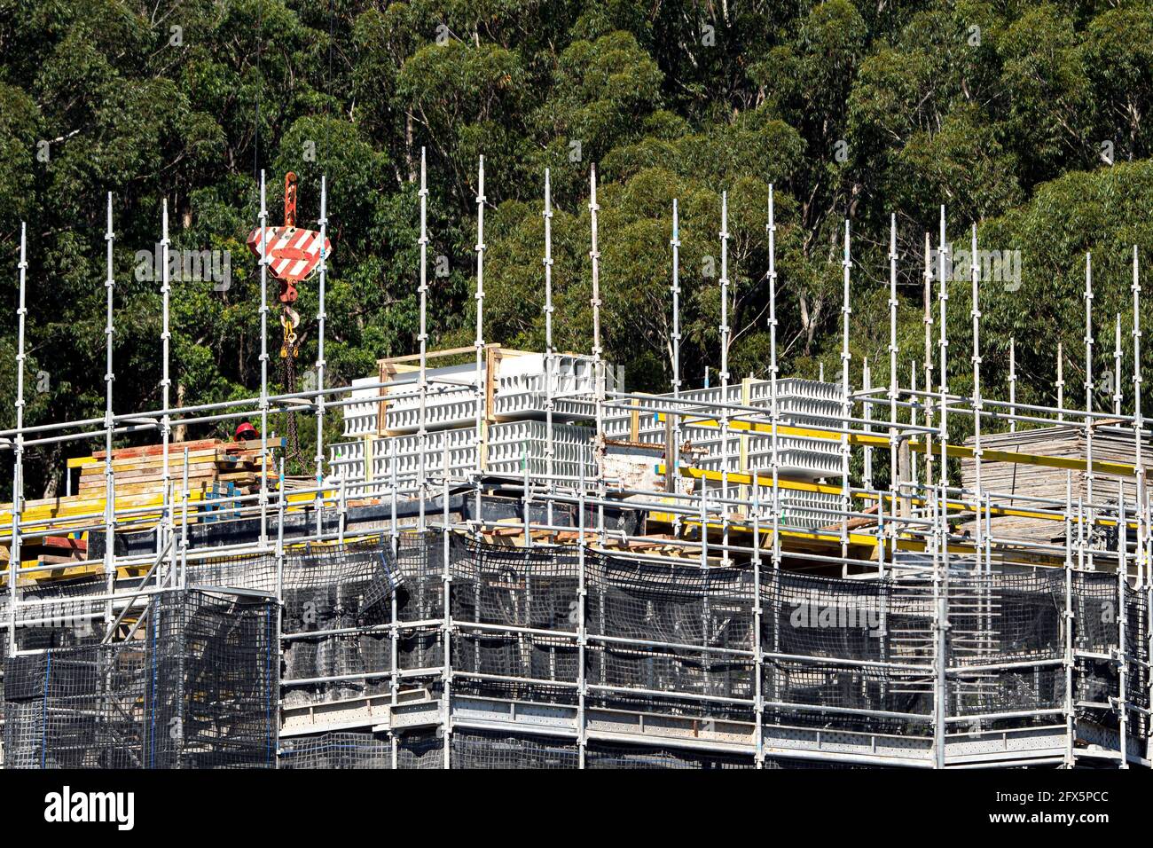 April 10, 2021. Worker loading PVC concrete wall formwork on new social housing at 56-58 Beane St. Gosford, Australia. Part of a building construction Stock Photo