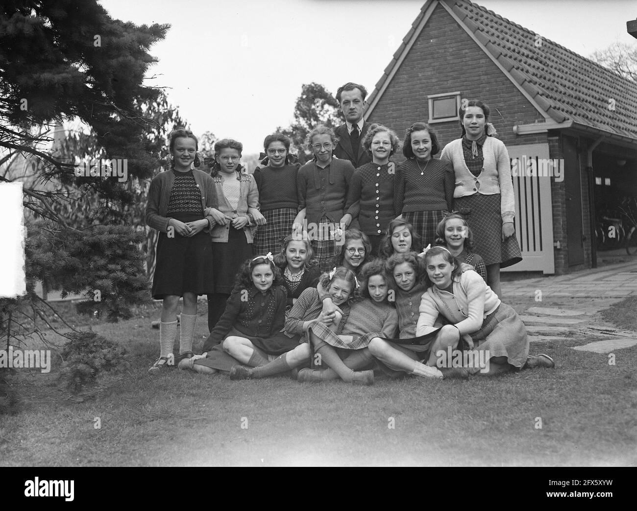Group of pupils and behind them, Mr. Sytsma, the AVO [general education] teacher of the Agricultural Household School Prinses Juliana in Zierikzee., March 3, 1949, group portraits, household schools, education, The Netherlands, 20th century press agency photo, news to remember, documentary, historic photography 1945-1990, visual stories, human history of the Twentieth Century, capturing moments in time Stock Photo