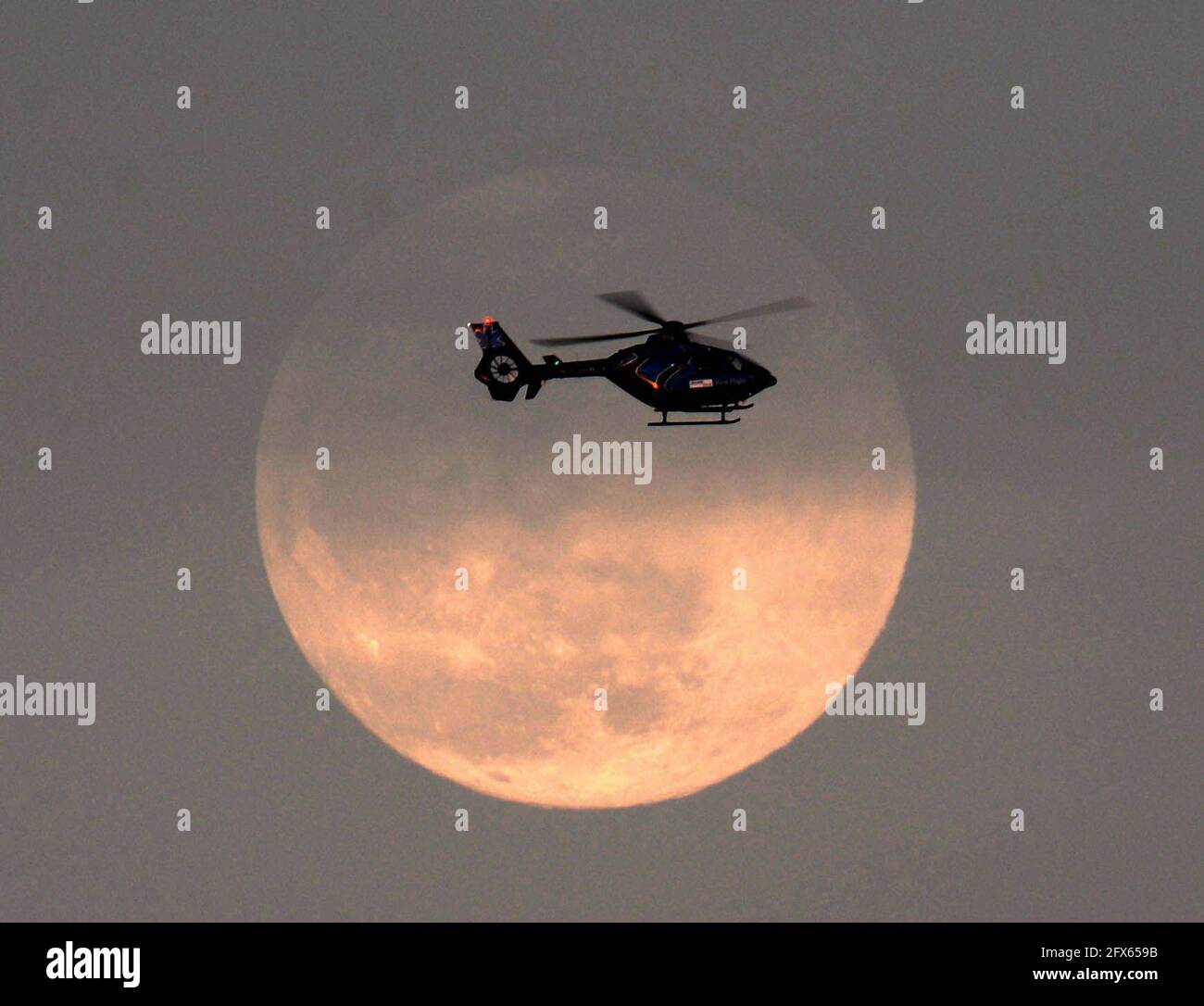 Melbourne. Brevard County, Florida. USA. May 25, 2021.Melbourne's Health First Air Medical Transport Helicopter passing the full moon. Photo Credit: Julian Leek/Alamy Live News Stock Photo