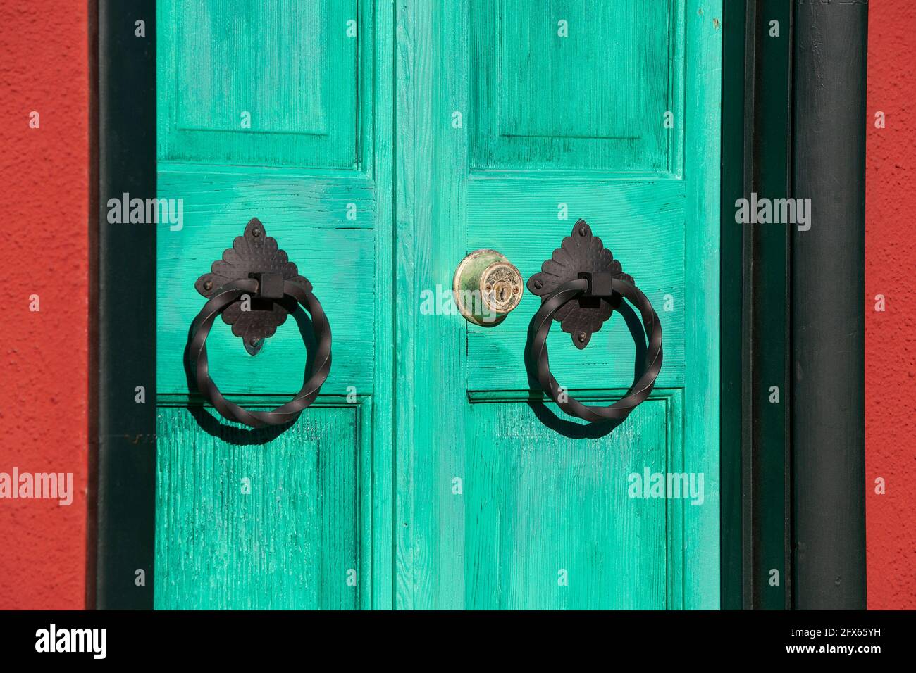 Aquamarine wooden door with ornate door knockers in Barrio Viejo, Tucson's historic old neighborhood Stock Photo