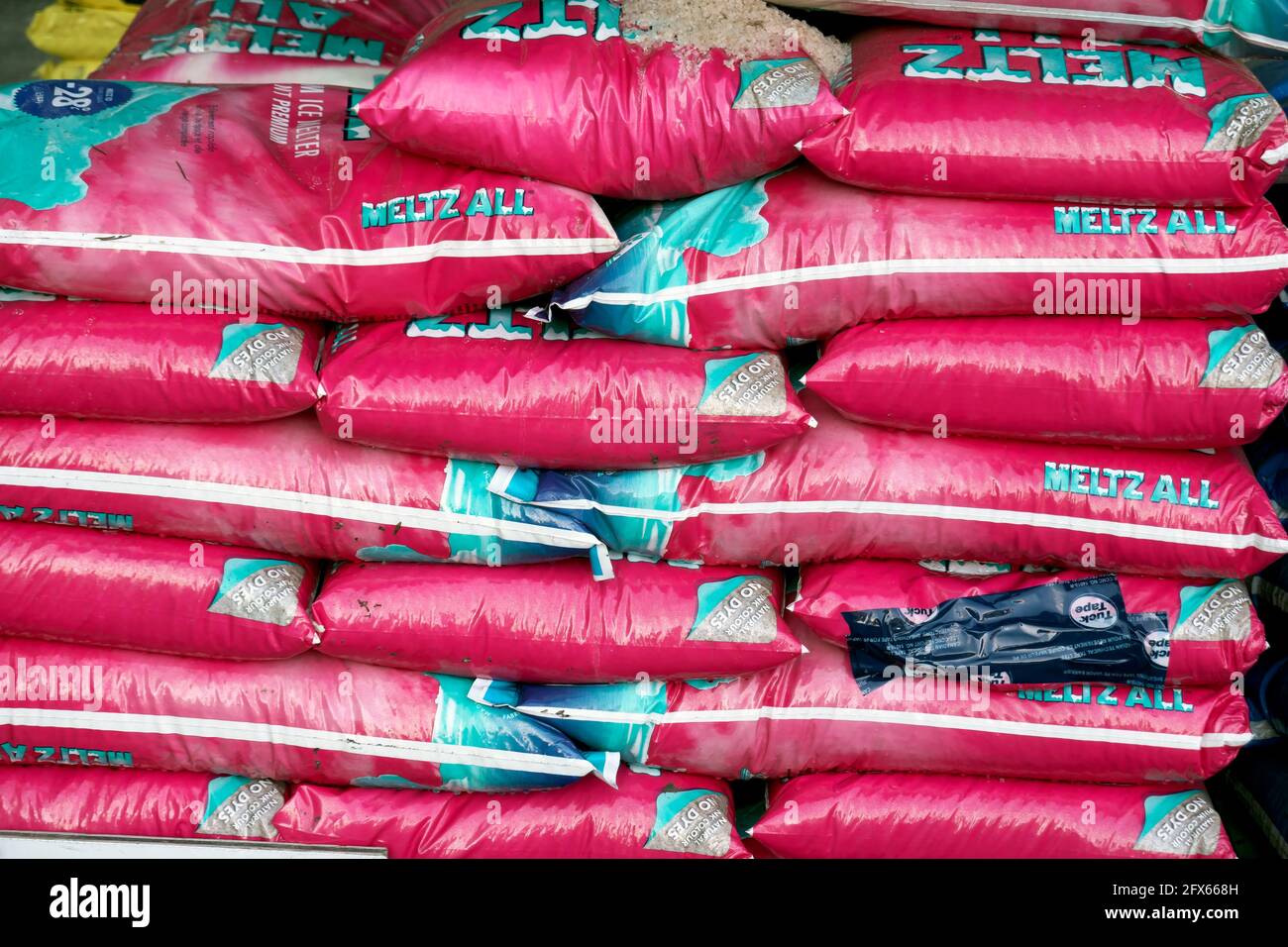 Stack of pink bags of Meltz All road salt for sale in a local retail outlet, Lower Mainland, B. C., Canada. Stock Photo