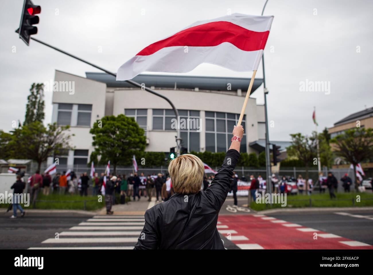 Warsaw, Poland. 25th May, 2021. A protester waves the forbidden historical Belarusian flag during the protest.Belarusians residents in Poland gathered outside the Embassy of Belarus to protest against the arrest of Roman Protesevich, dissident journalist and the repressions on activists by Aleksander Lukashenko. (Photo by Attila Husejnow/SOPA Images/Sipa USA) Credit: Sipa USA/Alamy Live News Stock Photo
