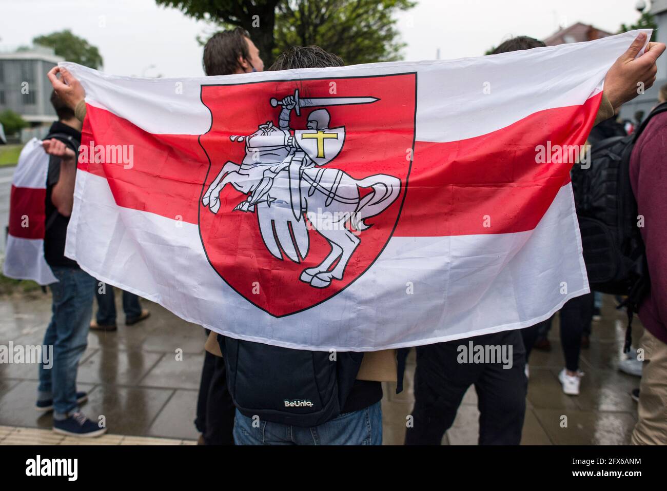 Warsaw, Poland. 25th May, 2021. A protester holds the forbidden historical Belarusian flag during the protest.Belarusians residents in Poland gathered outside the Embassy of Belarus to protest against the arrest of Roman Protesevich, dissident journalist and the repressions on activists by Aleksander Lukashenko. (Photo by Attila Husejnow/SOPA Images/Sipa USA) Credit: Sipa USA/Alamy Live News Stock Photo