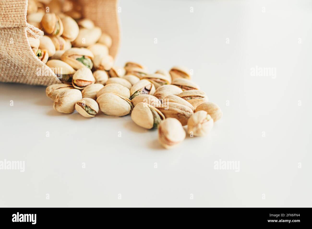 Pile of pistachios on the light background. Pistachio is a healthy