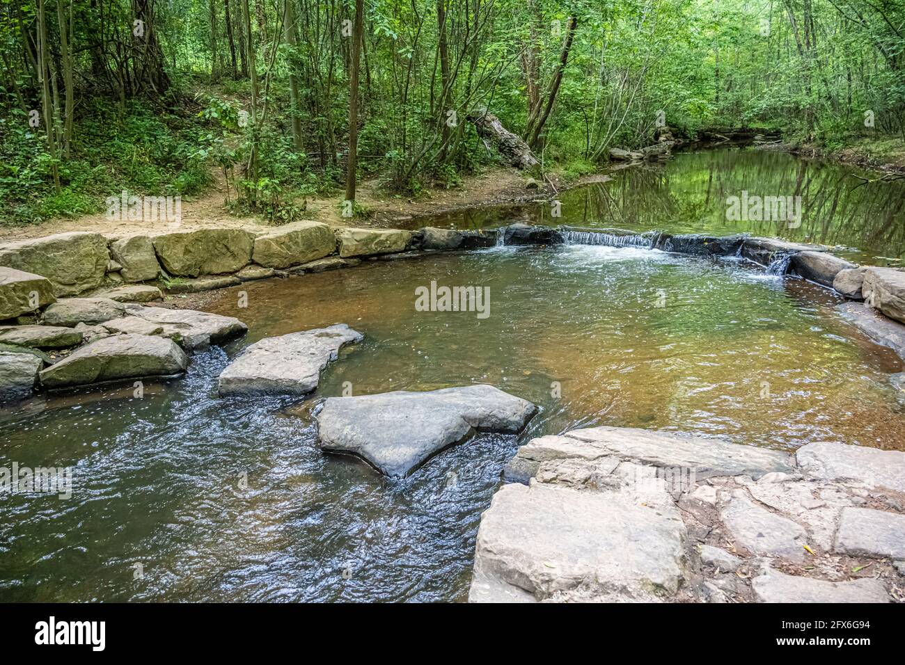 Peaceful stream with trail crossing rocks at Ronald Reagan Park in Lawrenceville, Georgia. (USA) Stock Photo