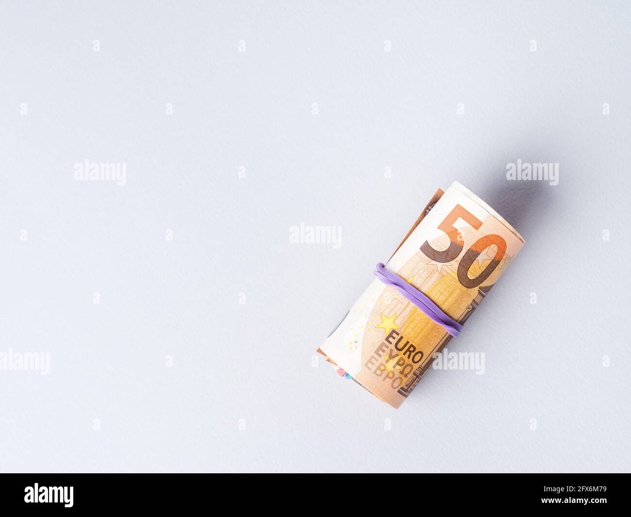 Euro 50 value banknotes roll with rubber on gray background Stock Photo ...