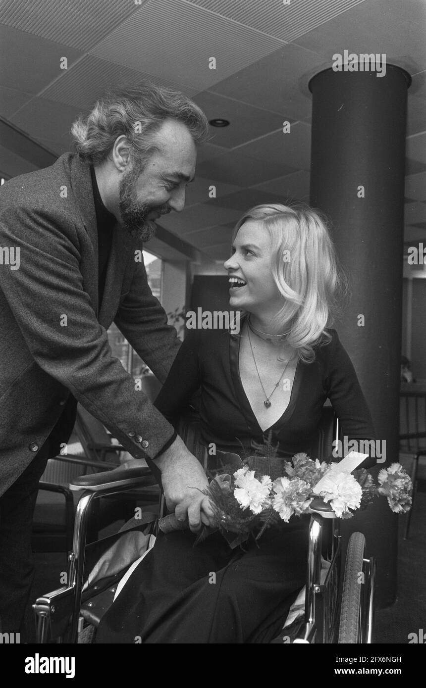 Lead actress Ans Beentjes in a wheelchair with director Roland Verhavert at the premiere of the film De Loteling in Amsterdam's City theater. Immediately after the shooting of the film, Beentjes contracted a viral infection after which she suffered severe paralysis and spent months in the Boerhaave clinic. For the premiere of The Lottery she was allowed to leave the hospital for a day. Six months later she was fully recovered., February 27, 1974, actresses, film premieres, directors, wheelchairs, The Netherlands, 20th century press agency photo, news to remember, documentary, historic Stock Photo