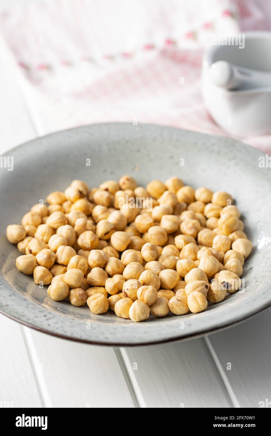 Peeled roasted hazelnut kernels in plate. Stock Photo