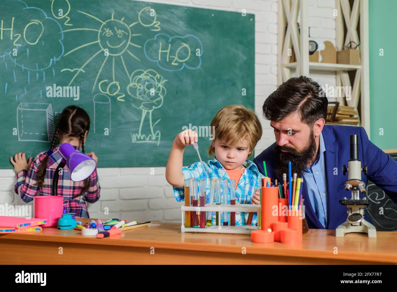 doing experiments with liquids in chemistry lab. children making science experiments. Education. back to school. chemistry lab. happy children teacher Stock Photo
