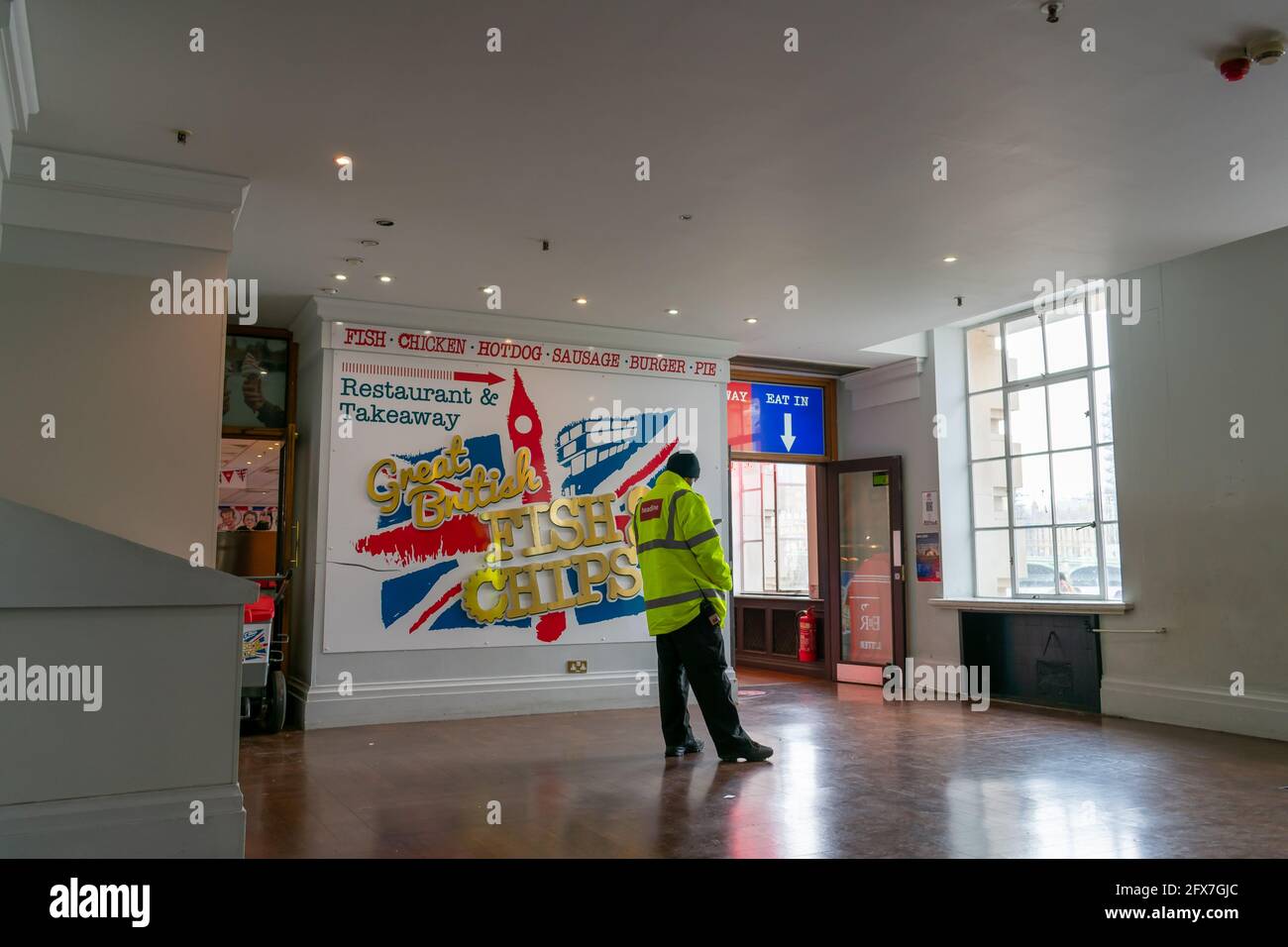 London. UK- 05.23.2021.  Interior of the Riverside Building  with a security staff by the entrance to a fish and chips restaurant. Stock Photo