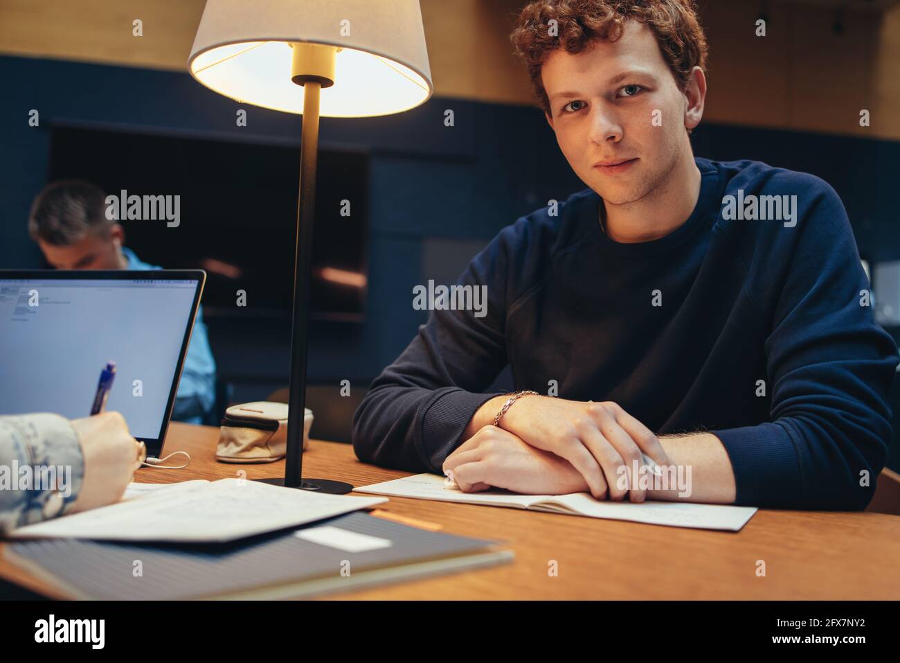 Portrait of university student in library looking at camera. Relaxed ...