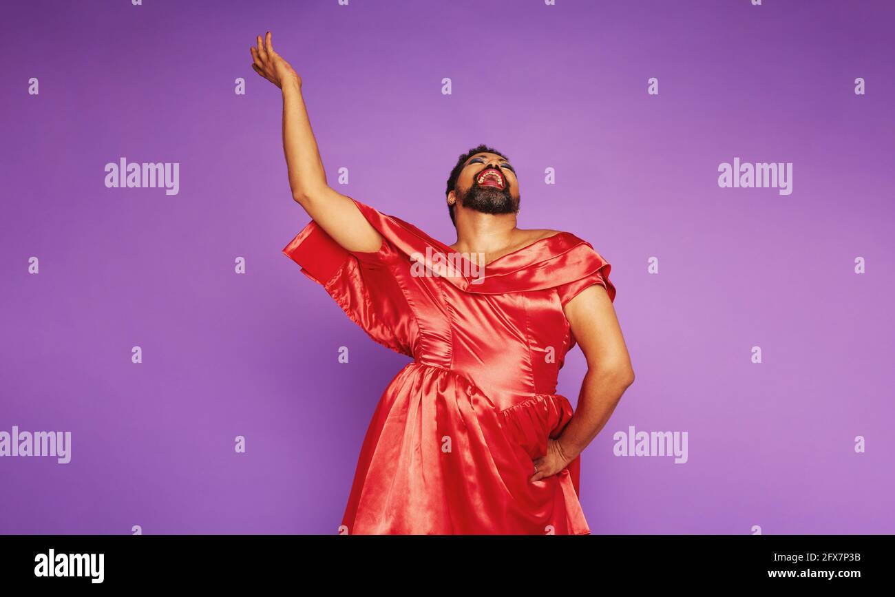 Drag queen singing on purple background. Gender queer male performing