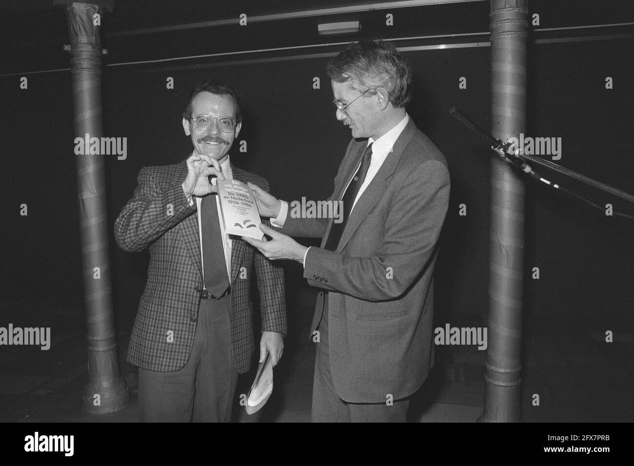 60-years existence VPRO celebrated in Brakke Grond in Amsterdam representative minister Brinkman (l) receives booklet from chairman De Jager, December 16, 1986, anniversaries, The Netherlands, 20th century press agency photo, news to remember, documentary, historic photography 1945-1990, visual stories, human history of the Twentieth Century, capturing moments in time Stock Photo