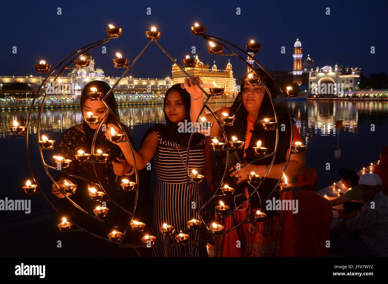 Amritsar. 25th May, 2021. Photo taken on May 25, 2021 shows devotees lighting lamps during the birth anniversary celebration of third Sikh Guru or Master, Guru Amar Das ji at the Golden Temple in Amritsar district of north Indian state of Punjab. Credit: Str/Xinhua/Alamy Live News Stock Photo