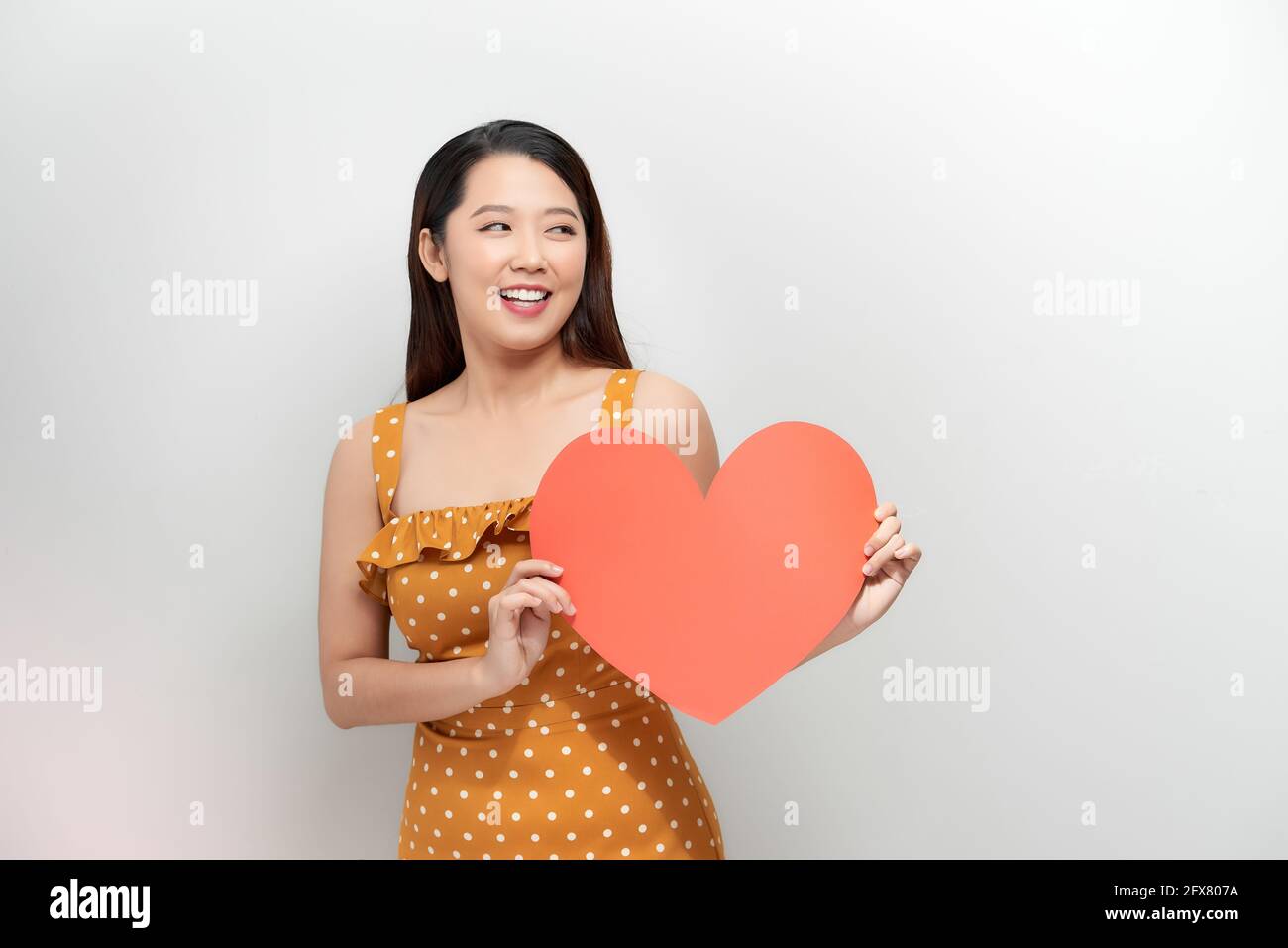 Photo of pretty lady hold hands hugging red paper heart affectionate ...