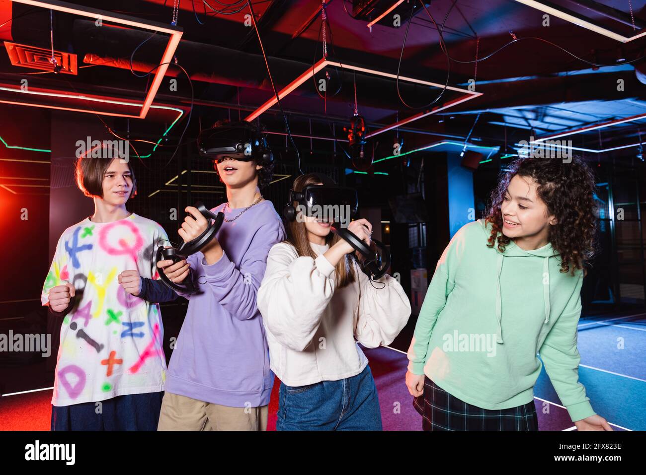 cheerful interracial friends spending time in vr play room Stock Photo