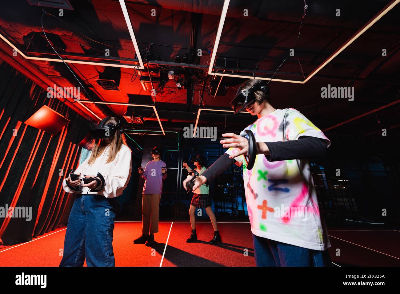 multicultural teenagers gaming in virtual reality play zone Stock Photo