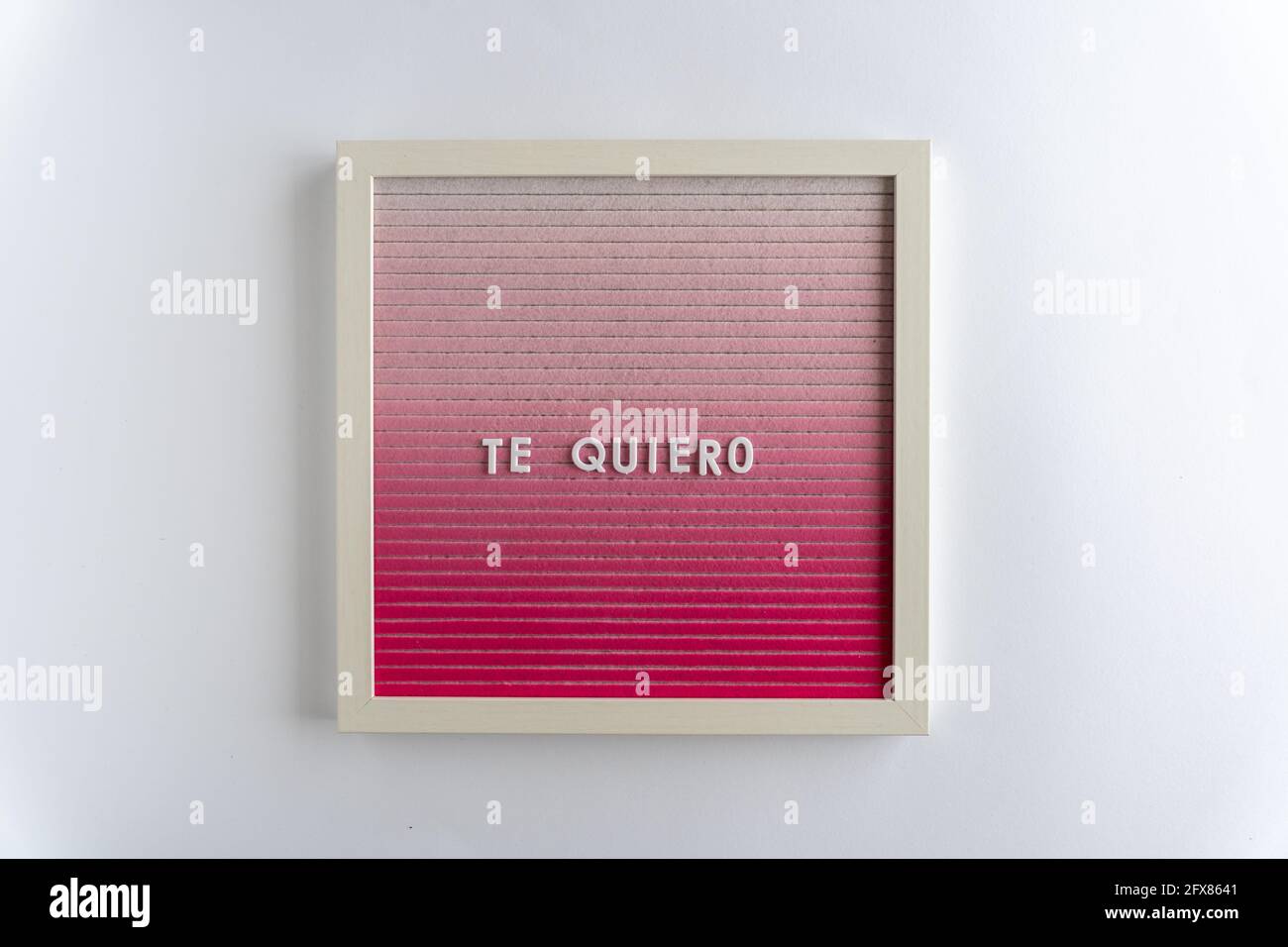 Pink Letterboard Words That Spell Te Quiero (translation: I love you), on a white background, horizontal Stock Photo